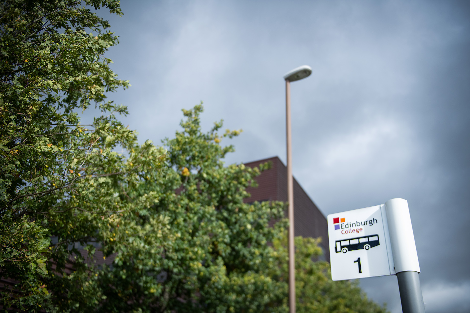 Bus stop sign outside Midlothian campus building.