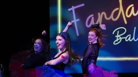 Three dancers perform on stage in colorful tutus, showcasing dynamic movement with a bright background that reads “Fandango Ballet.”