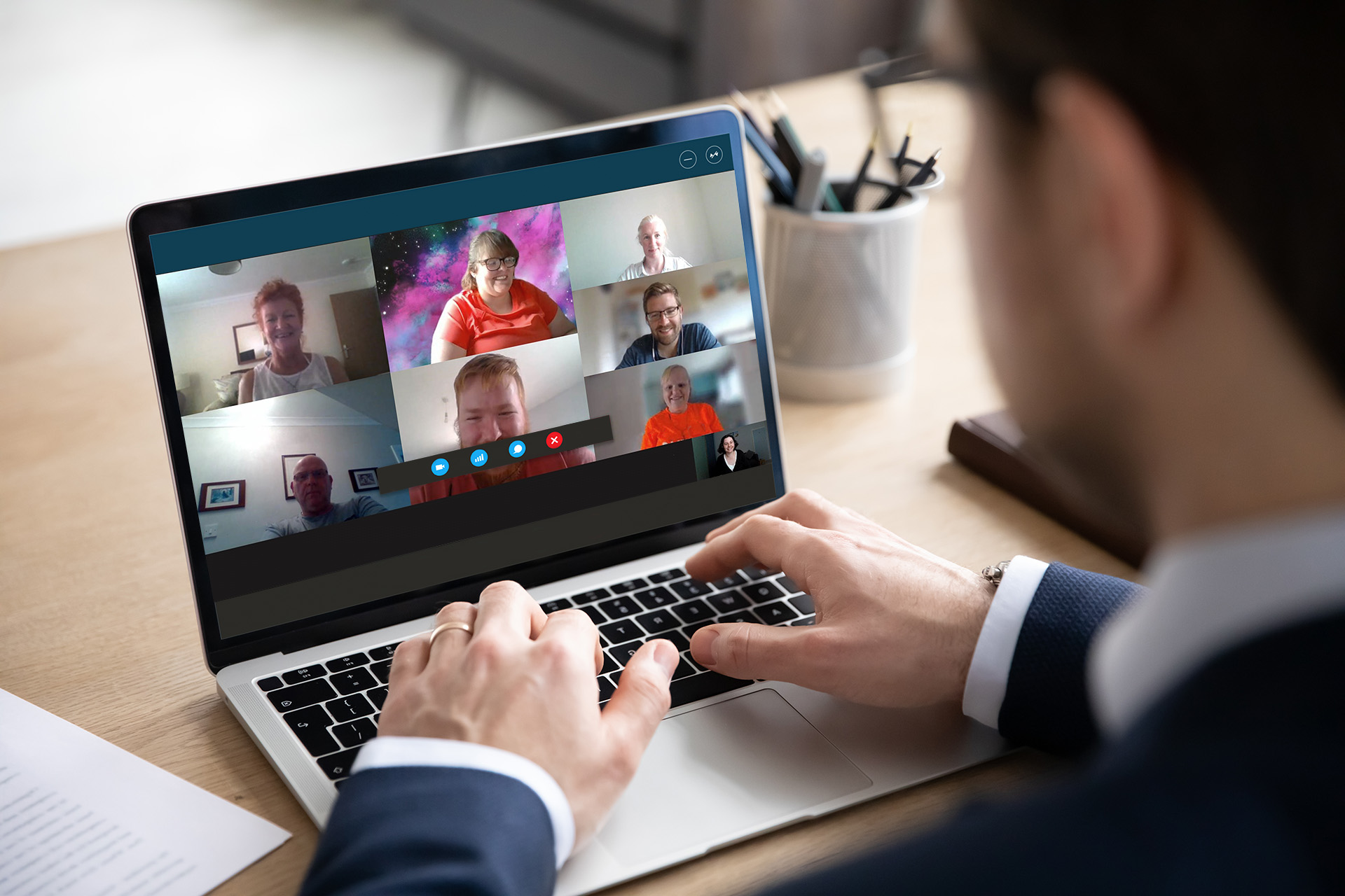 Business man wearing a suit is on a conference call on their laptop.