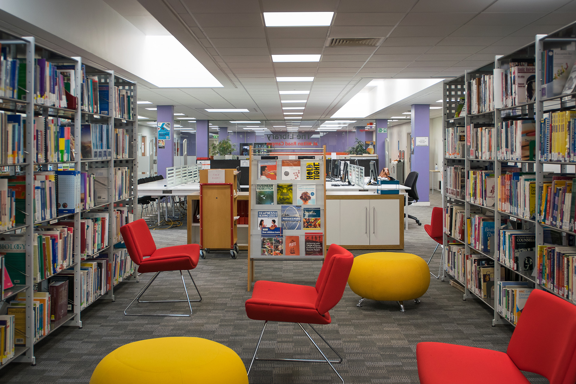 Red and yellow seats spread across the floor with bookshelves on either side.